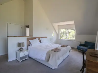 a bedroom with a white bed and a blue chair at Sobrachan in Braevallich
