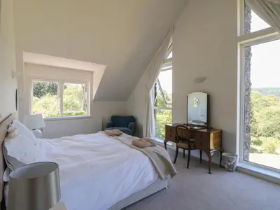 a bedroom with a bed and a desk and windows at Sobrachan in Braevallich
