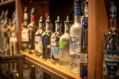 a row of bottles of alcohol sitting on a shelf at King Robert Hotel in Stirling