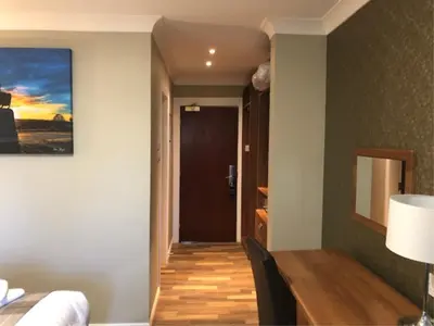 a room with a dining room table and a hallway at King Robert Hotel in Stirling