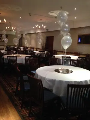 a banquet hall with white tables and balloons at King Robert Hotel in Stirling