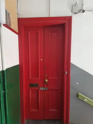 a red door in the corner of a room at Bentinck Street Ground Floor Apartment in Glasgow
