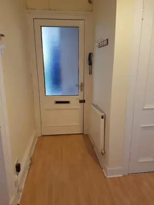 a white door with a window in a hallway at Bentinck Street Ground Floor Apartment in Glasgow