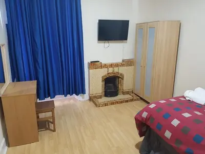 a bedroom with a fireplace and a blue curtain at Bentinck Street Ground Floor Apartment in Glasgow