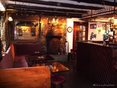 a restaurant with tables and a bar in a room at The Cross Keys Hotel in New Galloway