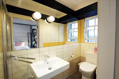 a bathroom with a sink and a toilet and a mirror at Revolver Edinburgh in Edinburgh