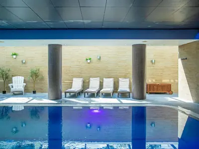 a group of chairs sitting next to a swimming pool at Novotel Edinburgh Park in Edinburgh