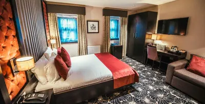 a hotel room with a bed and a couch at The Torrance Hotel in East Kilbride