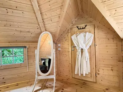 a cabin with a mirror and a chair in a room at Aos Sí Lodges in Ballachulish