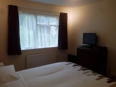 a bedroom with a bed and a window with a television at Homestay, Number 29, Dunollie in Oban