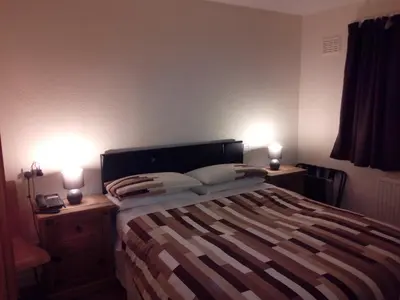 a bedroom with a bed and two lights on two tables at Homestay, Number 29, Dunollie in Oban
