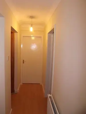 an empty hallway with a white door and a hallway at Homestay, Number 29, Dunollie in Oban