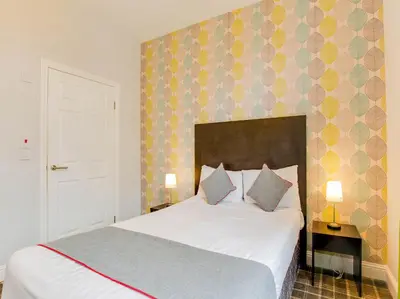 a bedroom with a large white bed with two pillows at Lost Guest House Stirling in Stirling