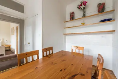 a dining room with a wooden table and chairs at 3 bed overlooking meadows park in Edinburgh