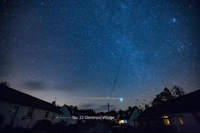 a starry night with a kite flying in the sky at Kelpies Cottage in Newton Stewart