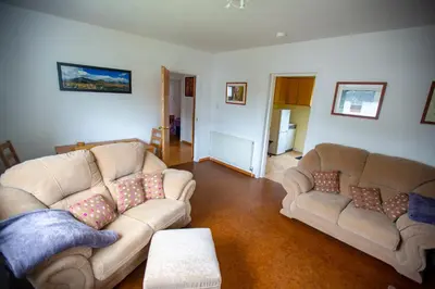 a living room with two couches and a table at Kelpies Cottage in Newton Stewart