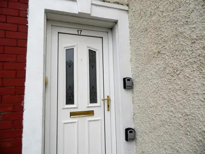 a white door on a building with a brick wall at Signature - Glen Lee House in Glasgow