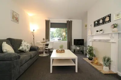 a living room with a couch and a fireplace at Signature - Glen Lee House in Glasgow