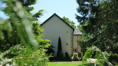 a large white building with a pointed roof at Arden Country House in Linlithgow