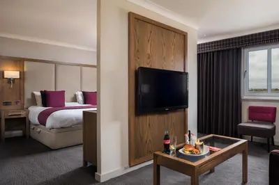 a hotel room with a bed and a flat screen tv at Radstone Hotel in Larkhall