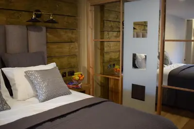 a bedroom with a bed and a wooden wall at The Corran in Onich