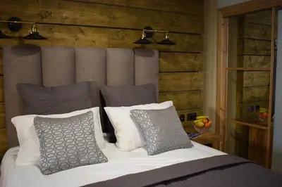 a bed with gray and white pillows in a bedroom at The Corran in Onich