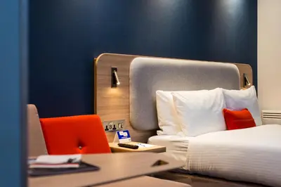 a hotel room with a bed and a chair at Holiday Inn Express Strathclyde Park M74, Jct 5 by IHG in Motherwell
