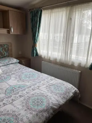 a bedroom with a bed and a window with curtains at Swift bordeaux 24 in Dunoon
