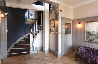 a hallway with a spiral staircase in a home at Ardencaple Hotel by Greene King Inns in Helensburgh