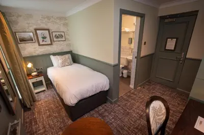 a small bedroom with a bed and a bathroom at Ardencaple Hotel by Greene King Inns in Helensburgh
