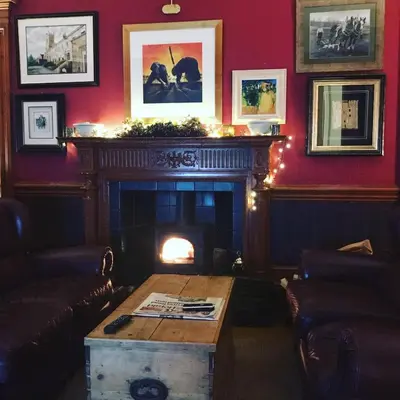 a living room with a fireplace and a table at Ashtree House Hotel, Glasgow Airport & Paisley in Paisley