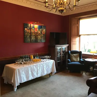 a dining room with a table with wine glasses on it at Ashtree House Hotel, Glasgow Airport & Paisley in Paisley
