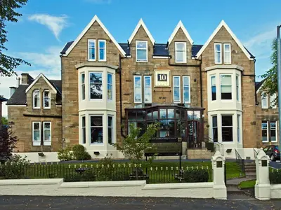 a large brick building with a bench in front of it at Number 10 Hotel in Glasgow