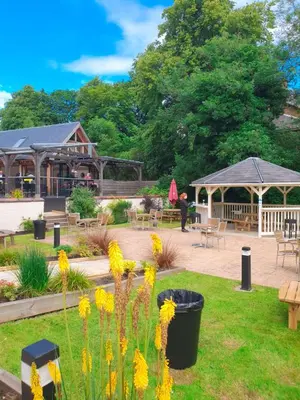 a garden with a cafe and tables and yellow flowers at Number 10 Hotel in Glasgow