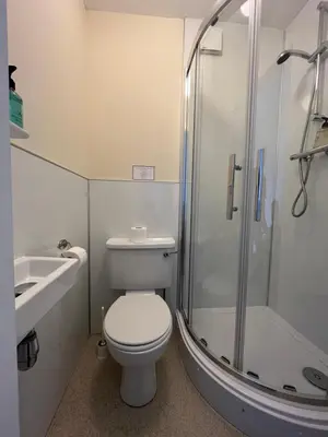 a bathroom with a toilet and a shower and a sink at The Kelvin Hotel in Oban