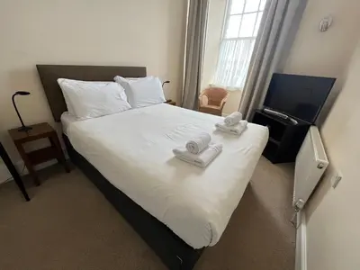 a bedroom with a bed with two towels on it at The Kelvin Hotel in Oban