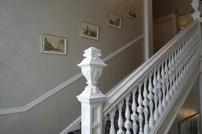 a staircase with white railings and paintings on the wall at Ashgrove House in Edinburgh