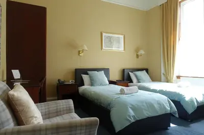a hotel room with two beds and a couch at Ashgrove House in Edinburgh