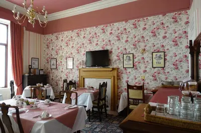 a dining room with tables and a tv on the wall at Ashgrove House in Edinburgh