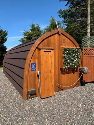 a large wooden hobbit house with a door at Kersebrock Kabins in Falkirk