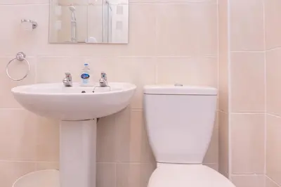 a bathroom with a white toilet and a sink at Peebles House - Coorie Doon Apartments in Ayr