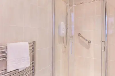 a bathroom with a shower with a glass door at Peebles House - Coorie Doon Apartments in Ayr