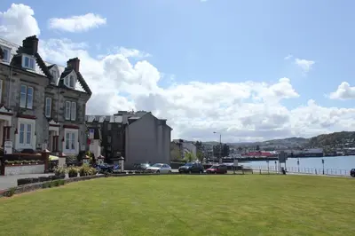 a park in front of a building with a grass field at Corran House Guest House in Oban