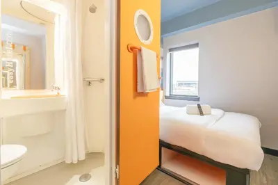 a bathroom with a bed and a toilet and a sink at easyHotel Glasgow City in Glasgow