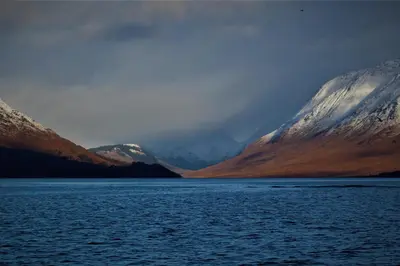 a view of a body of water with snow covered mountains at Tyndrum Lodges in Tyndrum