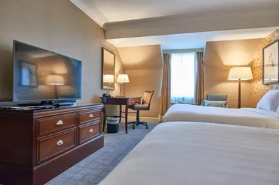 a hotel room with two beds and a flat screen tv at Dalmahoy Hotel & Country Club in Edinburgh