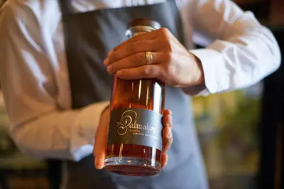 a man is holding a bottle of wine at Dalmahoy Hotel & Country Club in Edinburgh