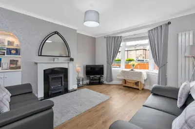 a living room with a couch and a fireplace at Crewe Apartment - Stylish 2 bedroom apt, Garden, Free parking, Edin City in Edinburgh