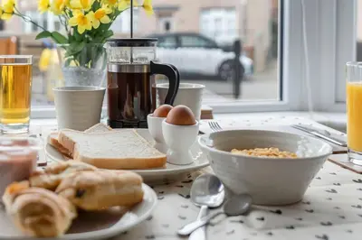 a breakfast table with eggs eggs bread and coffee at Crewe Apartment - Stylish 2 bedroom apt, Garden, Free parking, Edin City in Edinburgh
