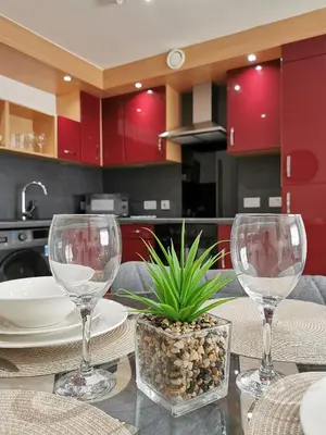 two wine glasses sitting on a table in a kitchen at Vkm Apartments in Glasgow